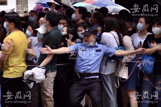 5月15日上午，安徽医科大学第二附属医院前来打疫苗的市民排成长队，公安、城管等工作人员在现场维持秩序。图源：安徽网 余康生 摄影